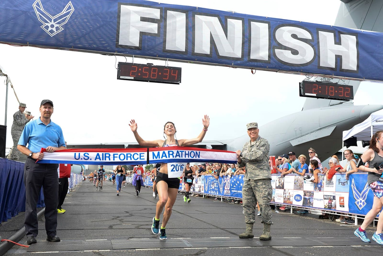 Air Force Marathon: women's winner breaks the tape at the 2016 air force marathon finish with a transport aircraft behind