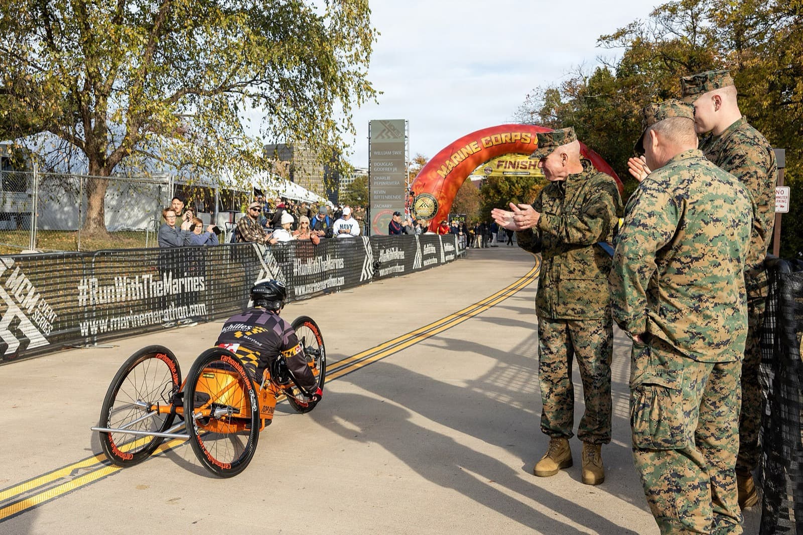 Marine Corps Marathon: handcyclist nears the marine corps marathon finish arch as marines applaud, 50th running