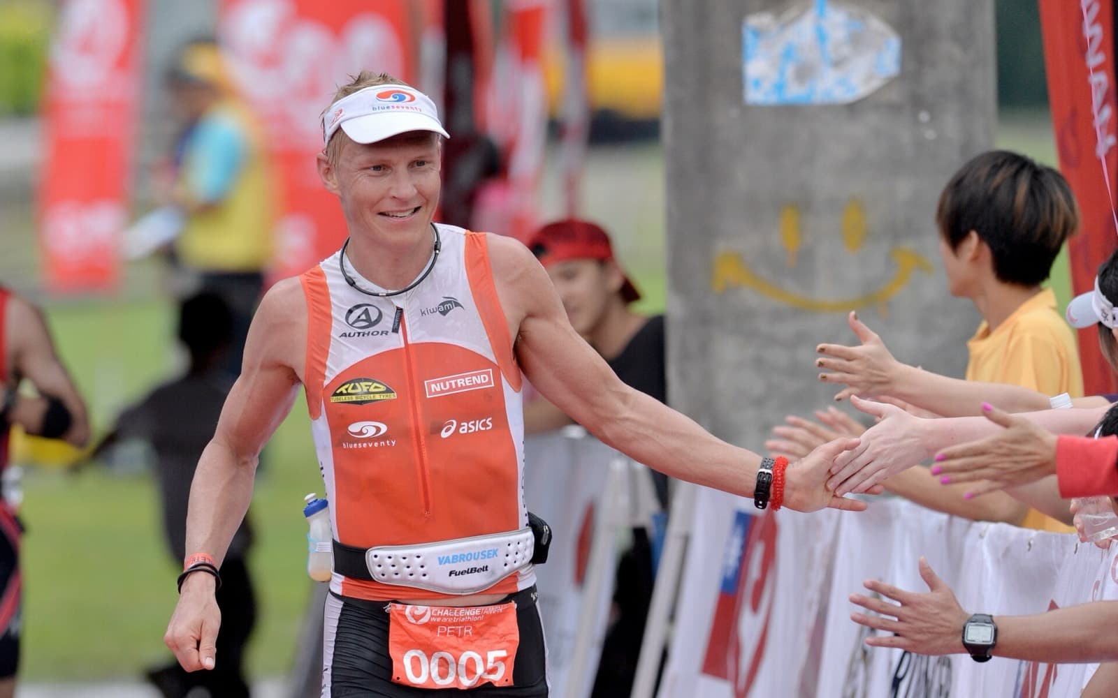 Challenge Taiwan (Middle Distance): petr vabrousek high-fiving spectators near the finish at challenge taiwan 2013