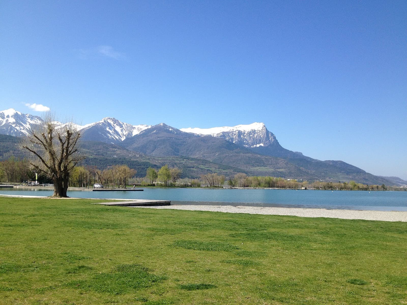 Triathlon d'Embrun L: embrun plan d'eau swim venue with snow-capped alpine peaks and pebble beach