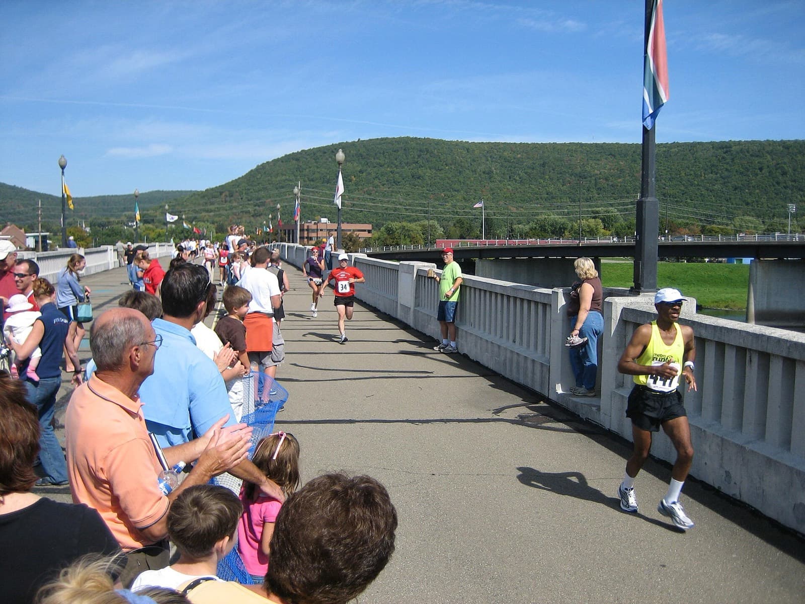 Guthrie Wineglass Marathon: runners crossing the pedestrian bridge near the finish in corning, spectators lining the rail