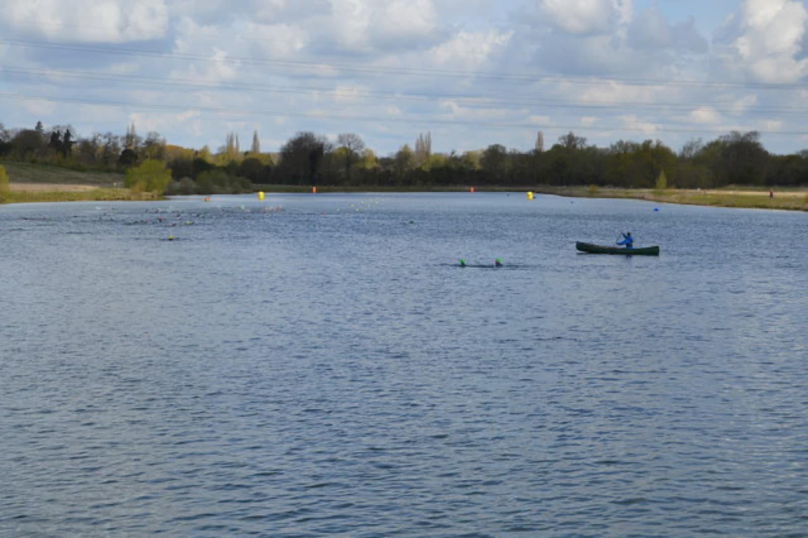 Box End Triathlon: swimmers and a canoe on the lake at box end park