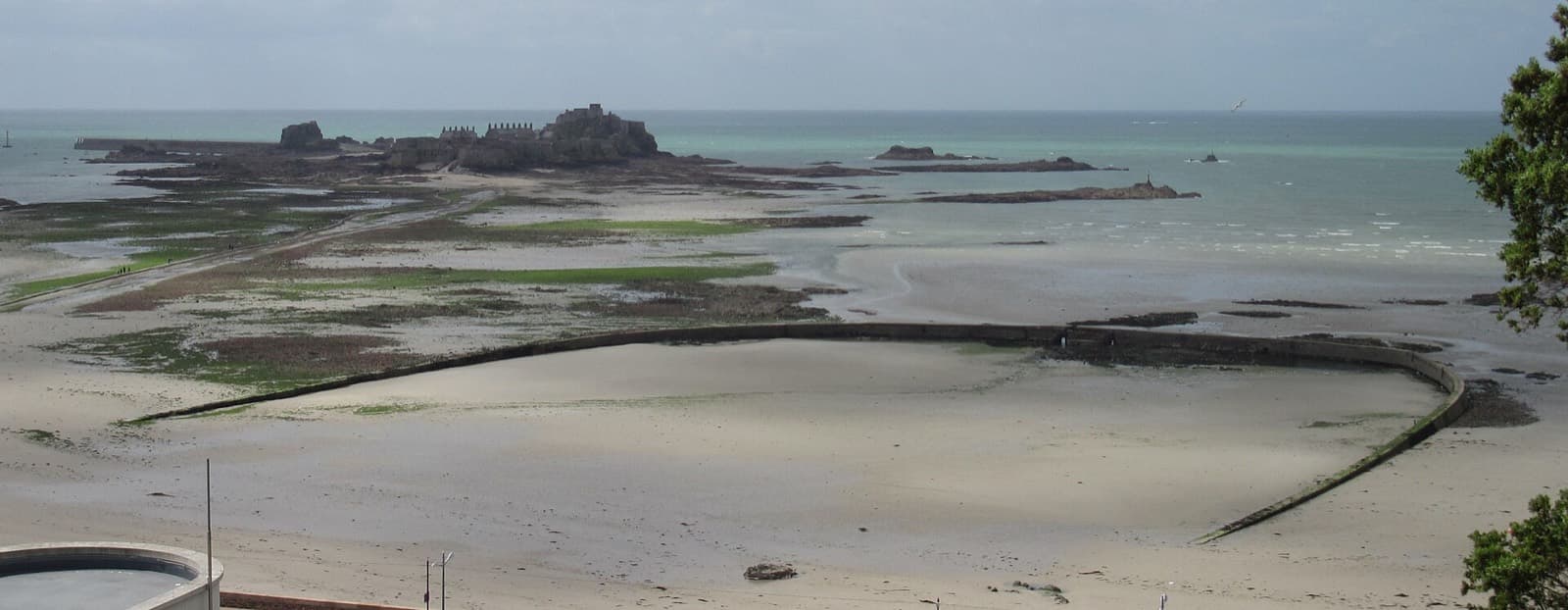 Accuro Jersey Triathlon: victoria marine lake at low tide with elizabeth castle, st helier