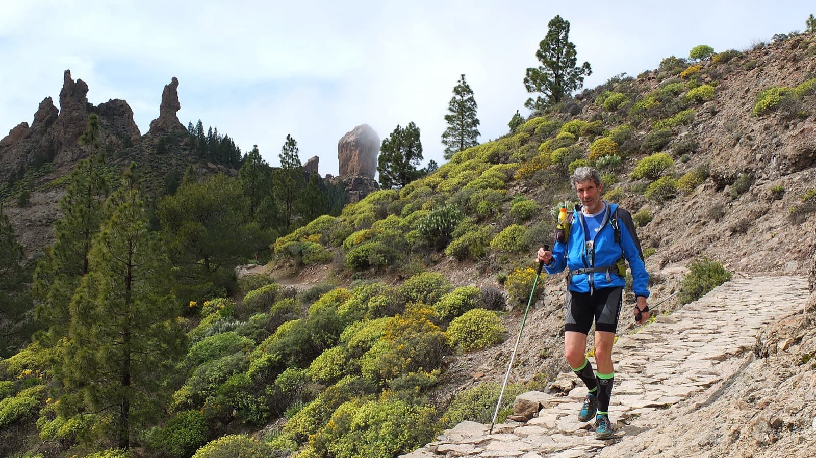The North Face Transgrancanaria Classic 126K: bibbed transgrancanaria 2013 runner with trekking poles on the rocky path up roque nublo
